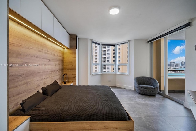 bedroom featuring wooden walls