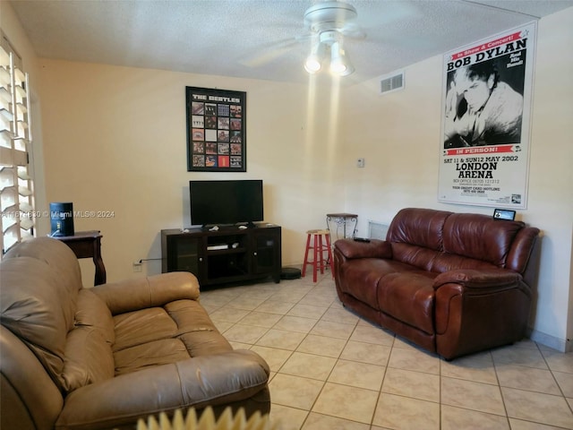 tiled living room with ceiling fan and a textured ceiling