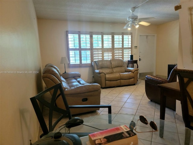 tiled living room featuring ceiling fan and a textured ceiling