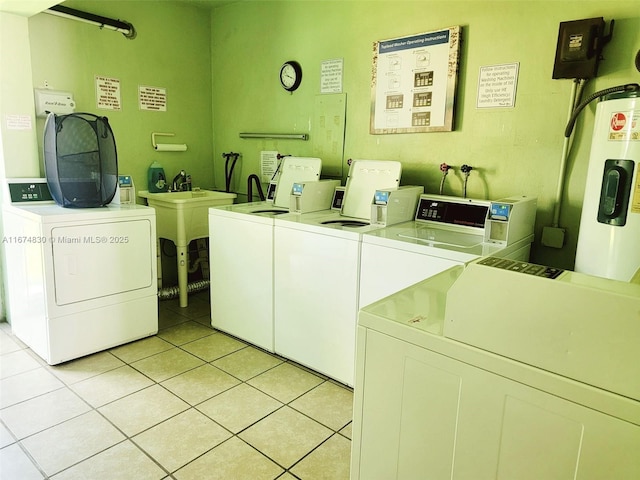 1900 NE 8th Ct Unit 203, Fort Lauderdale, FL 33304 - common laundry area with water heater, washing machine and clothes dryer, and light tile patterned floors