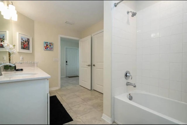 bathroom with tiled shower / bath, vanity, and tile patterned flooring