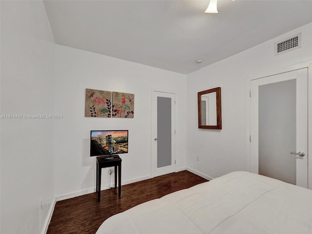 bedroom with dark hardwood / wood-style flooring