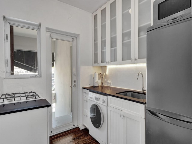 kitchen featuring built in fridge, dark hardwood / wood-style flooring, sink, washer / dryer, and white cabinets