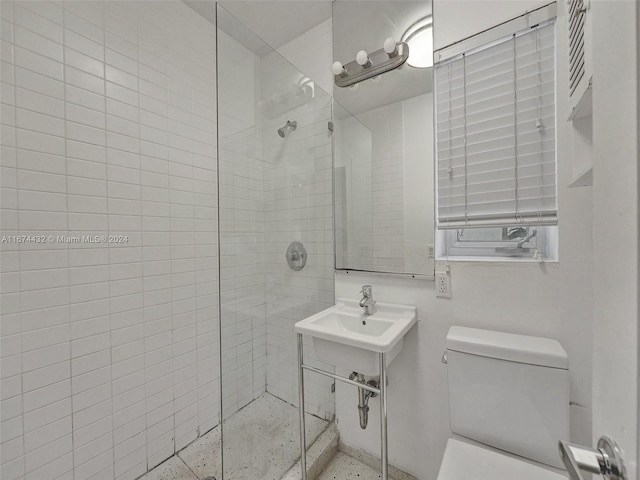 bathroom featuring sink, a shower with shower door, and toilet