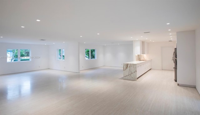 unfurnished living room featuring a healthy amount of sunlight and light wood-type flooring