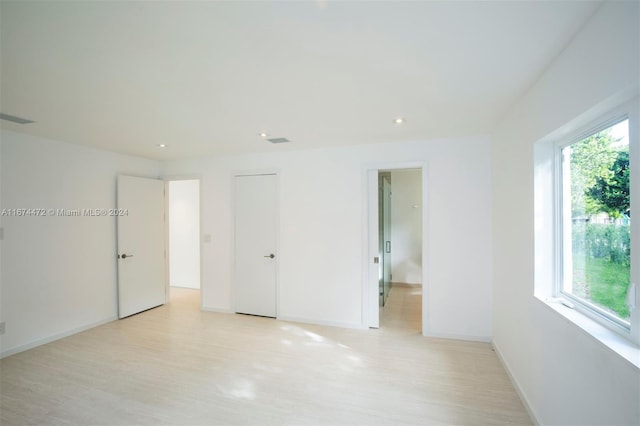 unfurnished room with light hardwood / wood-style floors and a healthy amount of sunlight