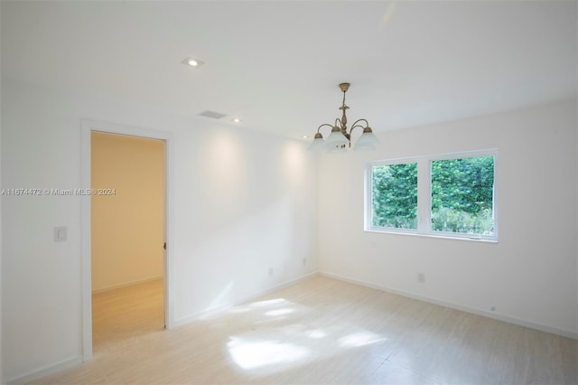 unfurnished room with a notable chandelier