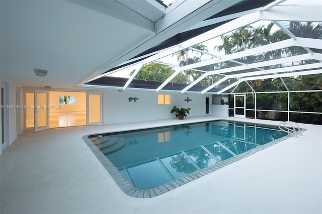 view of swimming pool with glass enclosure and a patio area