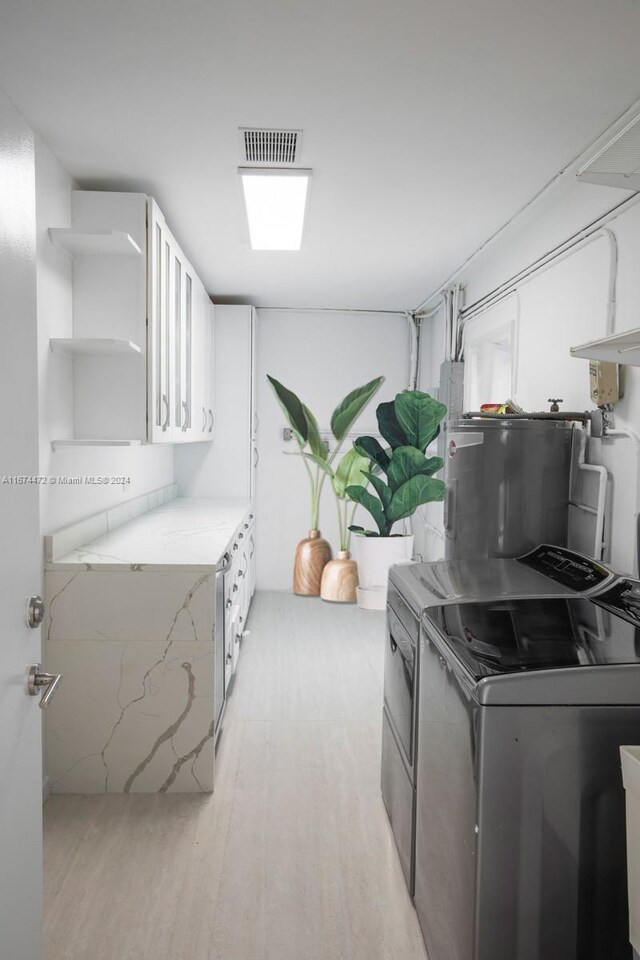 145 S Prospect Dr, Coral Gables, FL 33133 - laundry room with light wood-style floors, washer and clothes dryer, and electric water heater