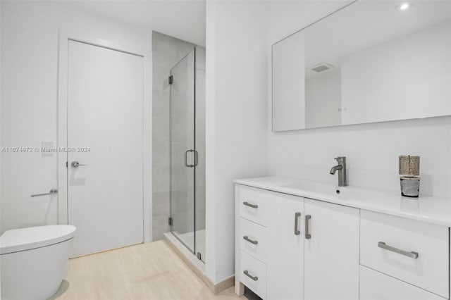 bathroom with vanity, a shower with shower door, and toilet