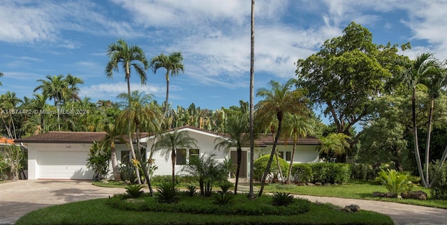 view of front of house featuring a garage and a front lawn