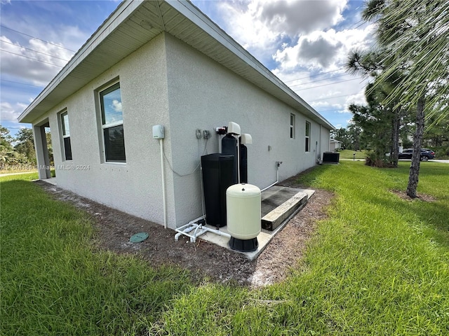 view of side of property with a yard and central air condition unit