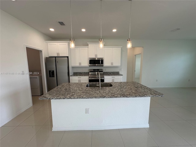 kitchen with washer / dryer, sink, decorative light fixtures, white cabinetry, and appliances with stainless steel finishes