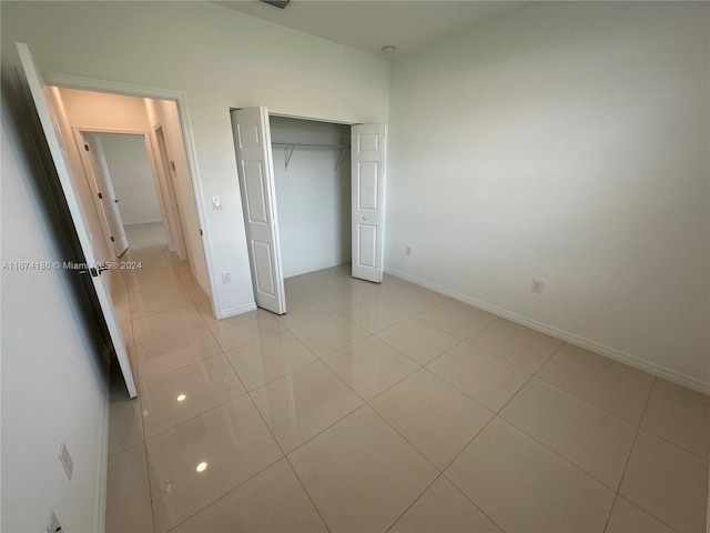 unfurnished bedroom featuring a closet and light tile patterned floors