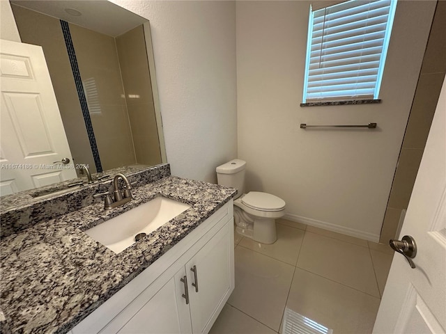 bathroom featuring toilet, vanity, and tile patterned flooring