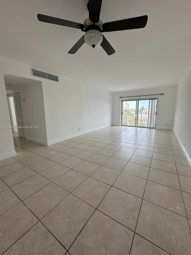 tiled empty room featuring ceiling fan