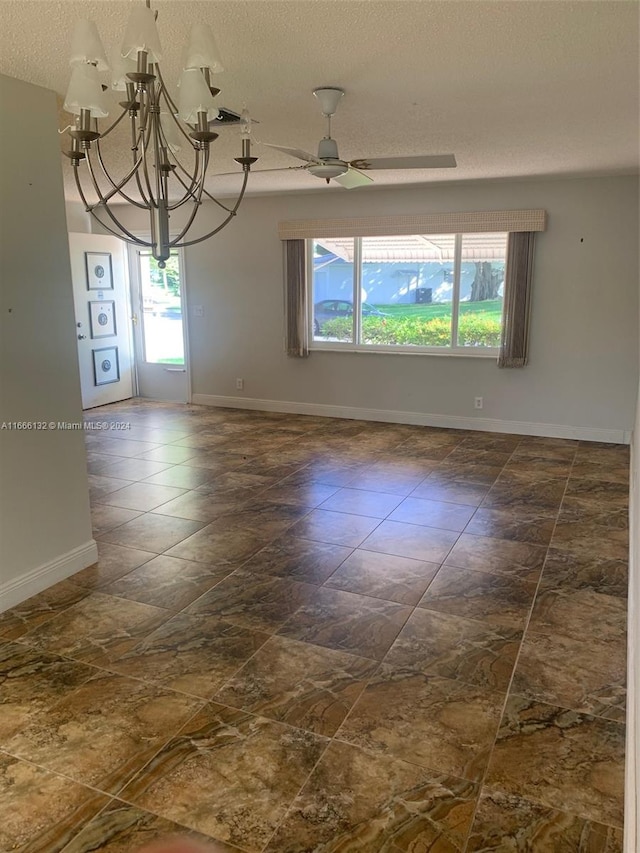 spare room with a textured ceiling and ceiling fan with notable chandelier