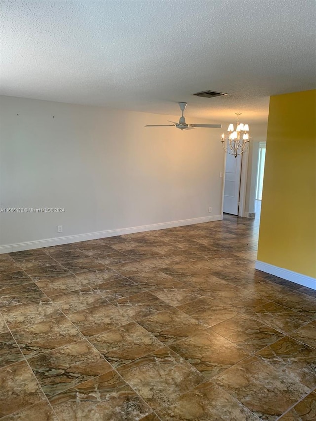 unfurnished room with a textured ceiling and ceiling fan with notable chandelier