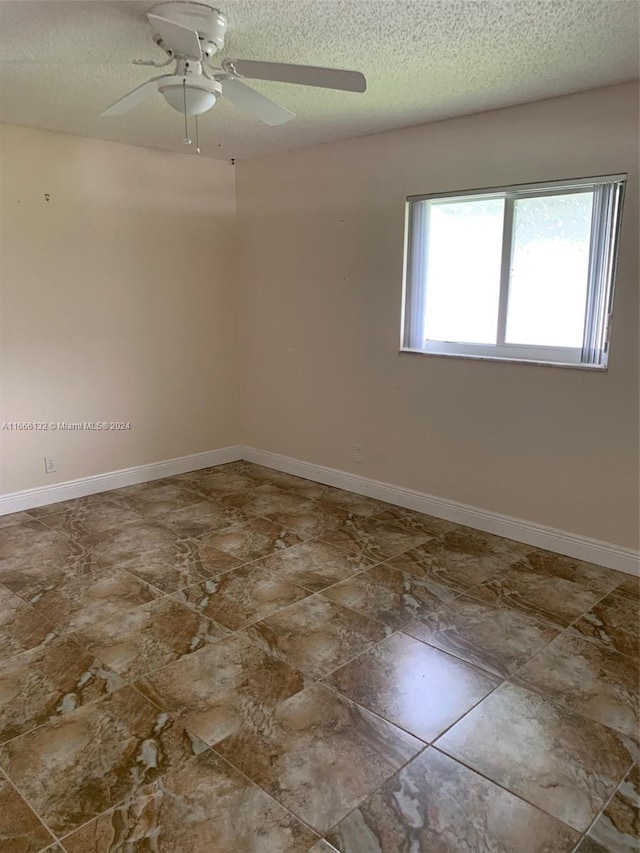 spare room featuring ceiling fan and a textured ceiling