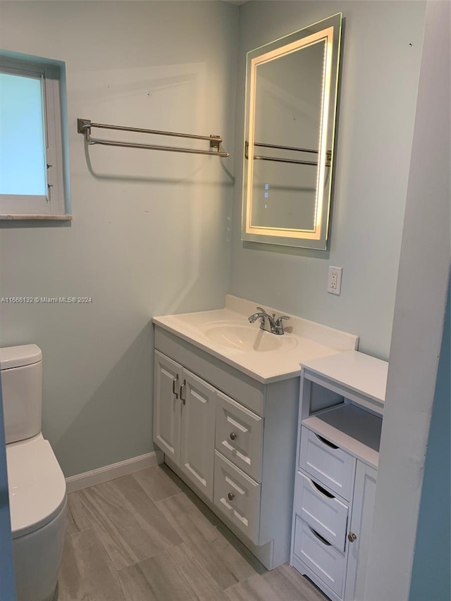 bathroom with vanity, toilet, and wood-type flooring