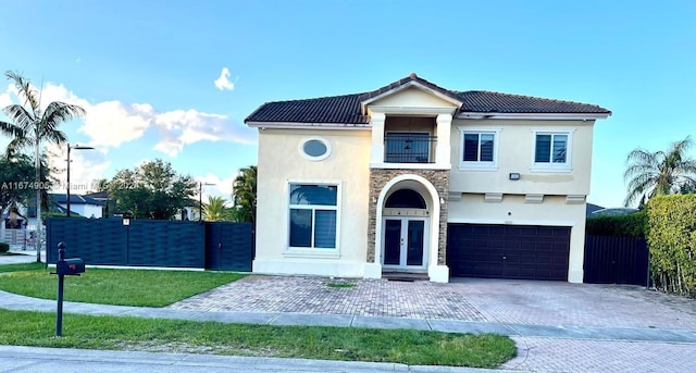 view of front of property with a balcony, a front yard, and a garage