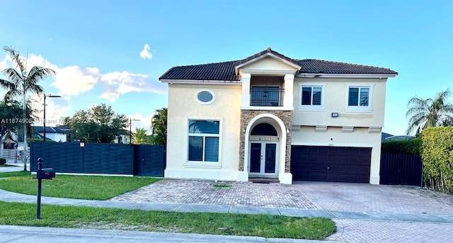 view of front of house featuring a balcony, a front lawn, and a garage