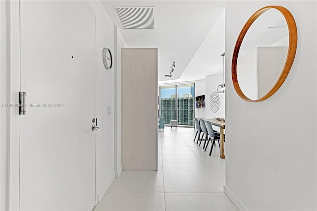 corridor featuring a wall of windows and light tile patterned floors