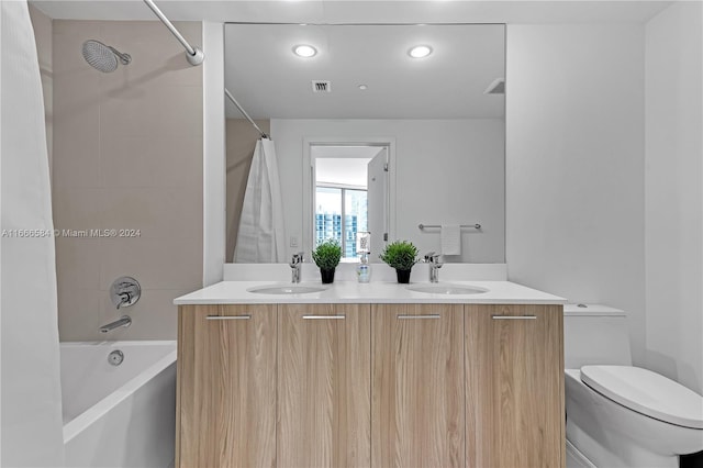 full bathroom featuring toilet, shower / bath combo with shower curtain, and vanity