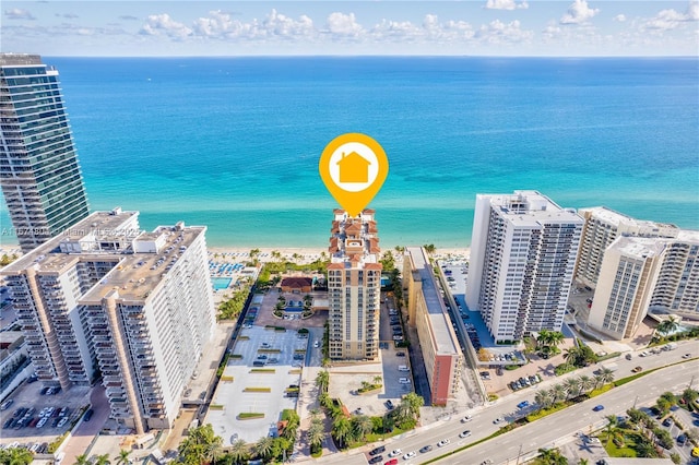 birds eye view of property featuring a water view and a beach view