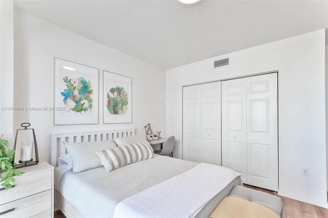 bedroom with hardwood / wood-style flooring and a closet