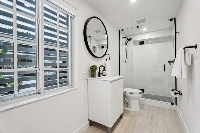 bathroom with vanity, toilet, and an enclosed shower