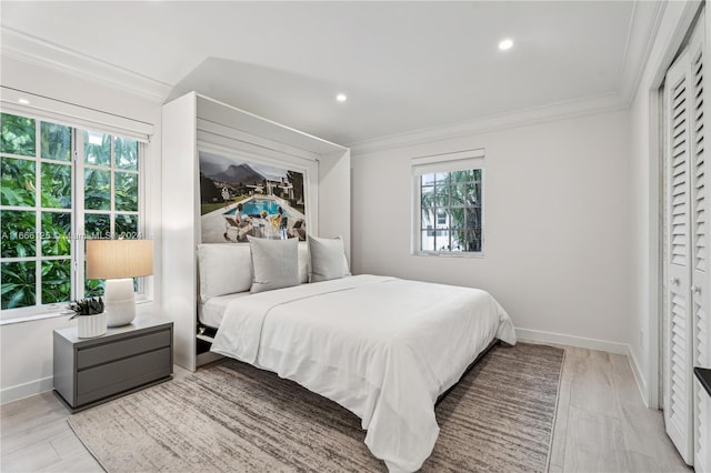 bedroom with ornamental molding and light wood-type flooring