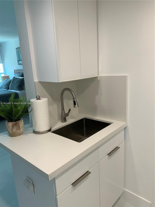 kitchen featuring white cabinetry and sink