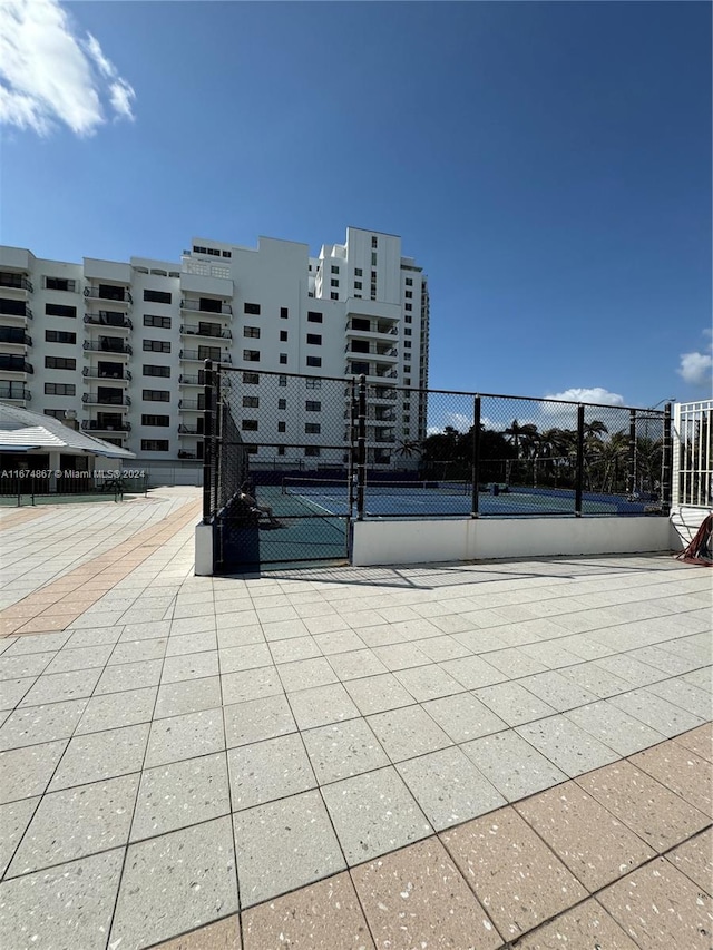 view of home's community with tennis court