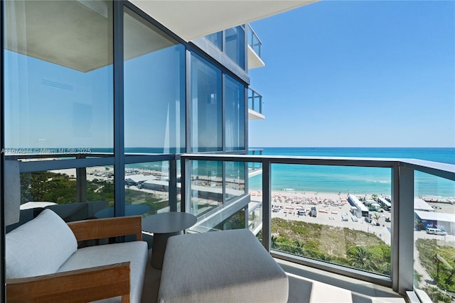 balcony featuring a water view and a beach view