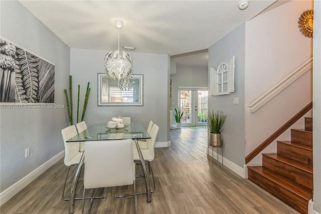 dining area featuring an inviting chandelier, wood-type flooring, and french doors