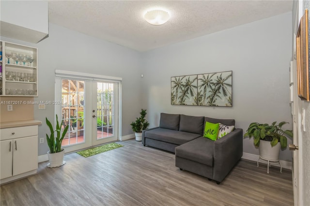 living room with french doors, a textured ceiling, and hardwood / wood-style flooring