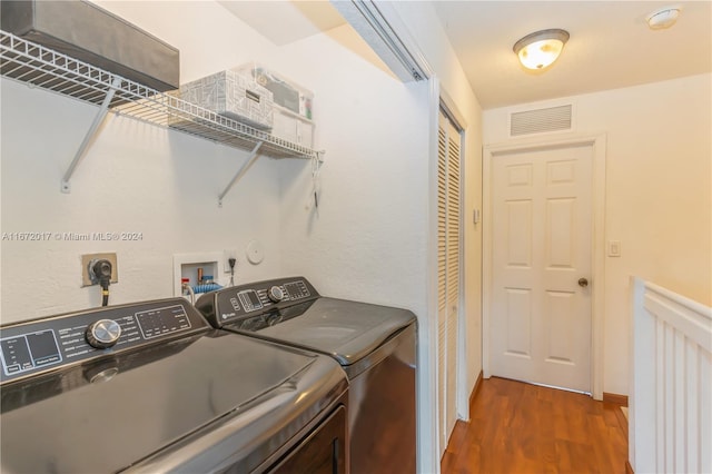 laundry room with washer and clothes dryer and dark hardwood / wood-style floors