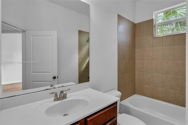 full bathroom with vanity, tiled shower / bath combo, and toilet