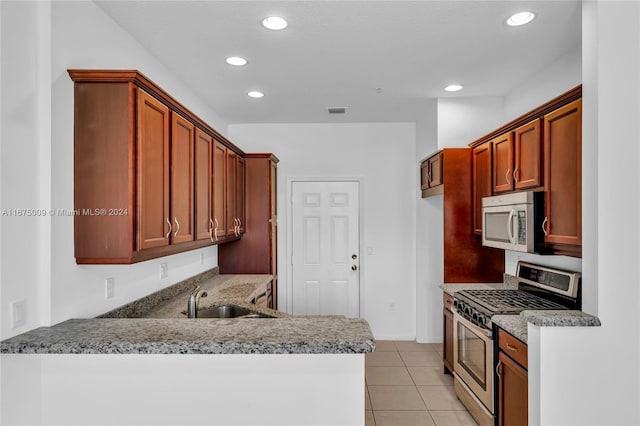 kitchen featuring light tile patterned floors, kitchen peninsula, sink, and appliances with stainless steel finishes