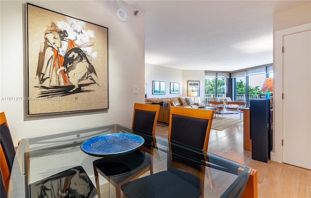 dining room featuring light hardwood / wood-style flooring and a wall of windows