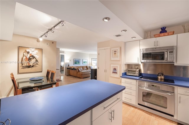 kitchen featuring light hardwood / wood-style flooring, white cabinetry, stainless steel appliances, and track lighting