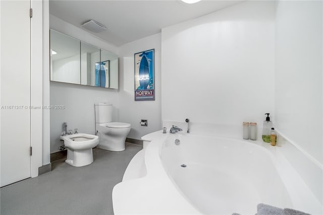 bathroom featuring toilet, a bidet, and a tub