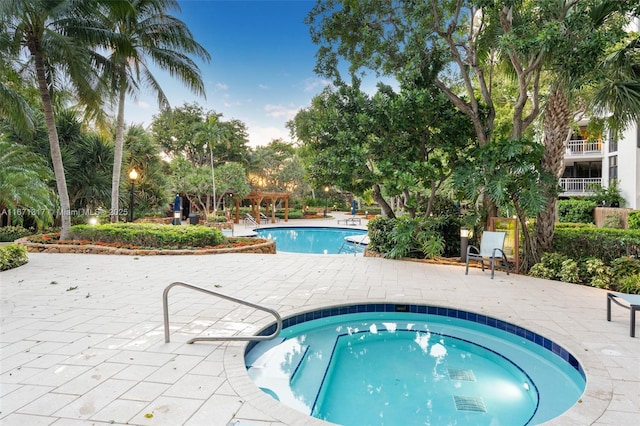 view of pool featuring a community hot tub and a patio