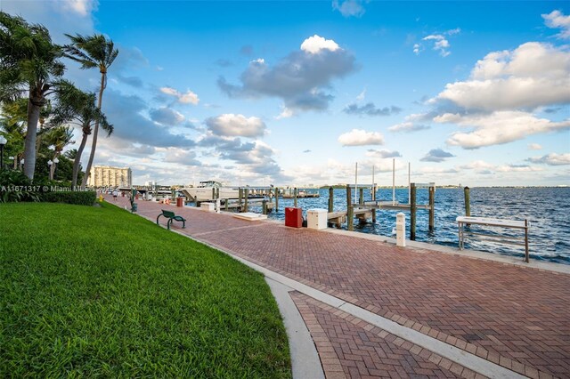 view of dock with a water view and a yard