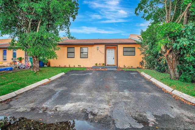 ranch-style home featuring a front lawn