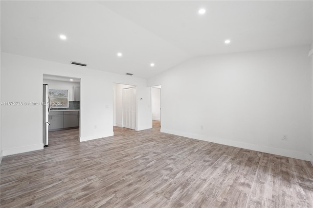 interior space with lofted ceiling and light hardwood / wood-style floors