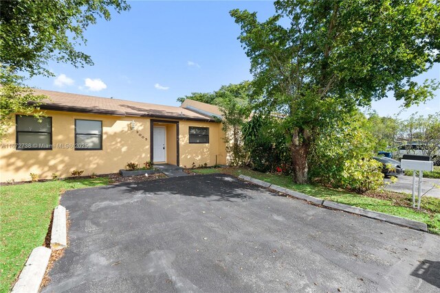 rear view of property featuring a lawn