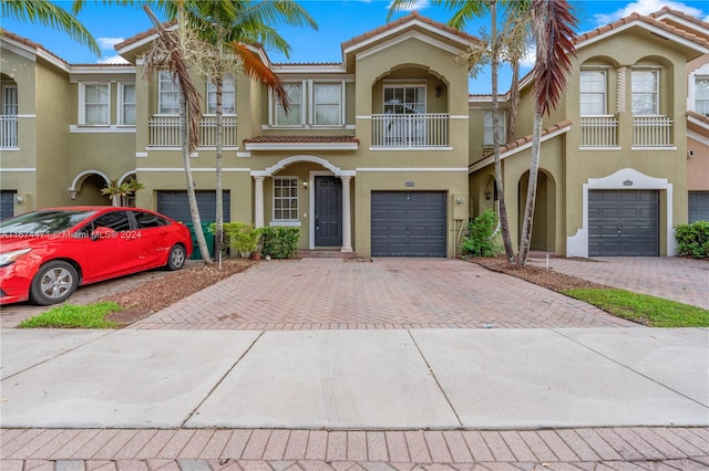 townhome / multi-family property featuring a balcony and a garage