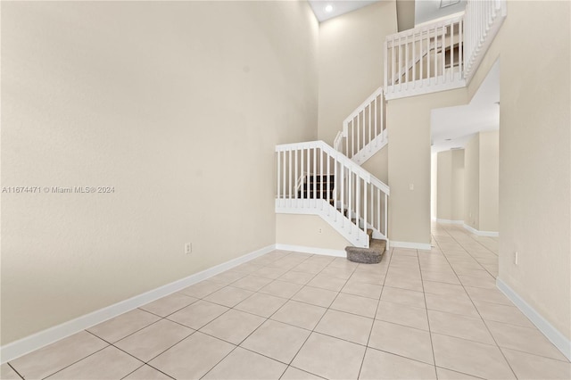 stairs with a high ceiling and tile patterned floors